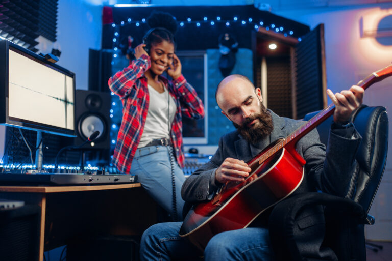 Two people working on music production